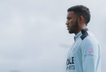 El futbolista venezolano Keiber Lamadrid de perfil, vistiendo la indumentaria de entrenamiento azul claro del West Ham United con patrocinantes visibles como BoyleSports, Lilley Plummer Risks y Cle Sports, bajo un cielo nublado de fondo.