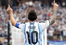 Lionel Messi de espaldas celebrando con los dedos apuntando al cielo, vistiendo la camiseta número 10 de la selección de Argentina durante la Copa del Mundo.