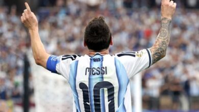 Lionel Messi de espaldas celebrando con los dedos apuntando al cielo, vistiendo la camiseta número 10 de la selección de Argentina durante la Copa del Mundo.