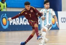 Dos jugadores disputan el balón en el partido de semifinales del Sudamericano de Futsal Sub-17 entre Venezuela y Argentina. El jugador venezolano, vistiendo la camiseta Vinotinto con el número 7, controla la pelota mientras es presionado por el jugador argentino con el uniforme albiceleste y el dorsal 13.