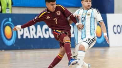 Dos jugadores disputan el balón en el partido de semifinales del Sudamericano de Futsal Sub-17 entre Venezuela y Argentina. El jugador venezolano, vistiendo la camiseta Vinotinto con el número 7, controla la pelota mientras es presionado por el jugador argentino con el uniforme albiceleste y el dorsal 13.
