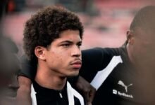 El futbolista venezolano David Martínez en un plano medio durante su presentación oficial con el FC Midtjylland, vistiendo uniforme Puma con patrocinio de Sydbank junto a sus compañeros.