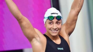 La nadadora venezolana Lismar Lyon sonríe con los brazos en alto celebrando una victoria en la piscina.