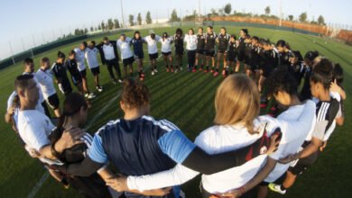 Cuerpo técnico y futbolistas de la Vinotinto femenina tomados de los hombros formando un círculo en el campo durante un entrenamiento previo al debut en el Mundial.