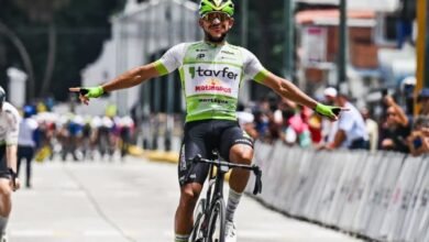 El ciclista Leangel Linarez, con los brazos abiertos y una sonrisa, celebra su victoria al cruzar la línea de meta con el uniforme verde y blanco del equipo Tavfer-Ovos Matinados-Mortágua durante la Vuelta a Venezuela